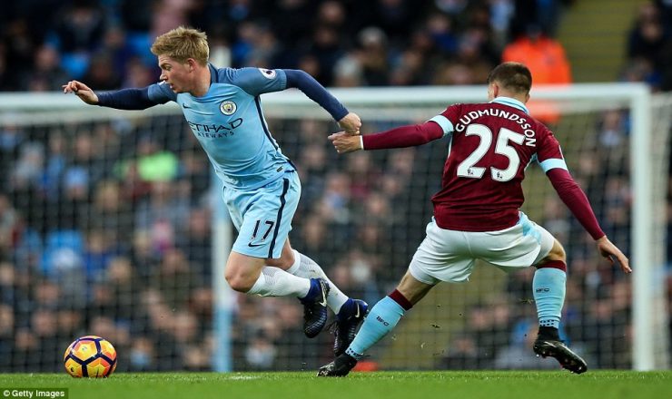 Manchester City playmaker Kevin De Bruyne (left) skips past Gudmundsson as he tries to start an attack for his side